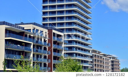 European residential architecture harmonizing with nature. Eco-friendly living in city with greens. Eco apartment building saving energy and fresh air concept.  128172182