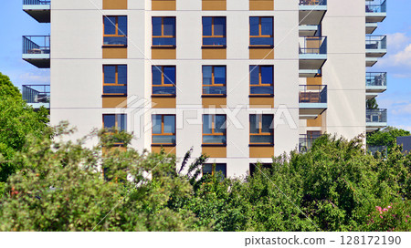 European residential architecture harmonizing with nature. Eco-friendly living in city with greens. Eco apartment building saving energy and fresh air concept.  128172190