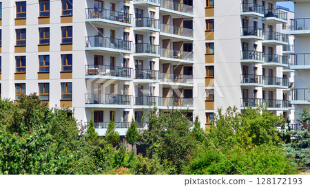 European residential architecture harmonizing with nature. Eco-friendly living in city with greens. Eco apartment building saving energy and fresh air concept. European residential architecture harmonizing with nature. Eco-friendly living in city with greens. Eco apartment building saving energy and fresh air concept. 128172193