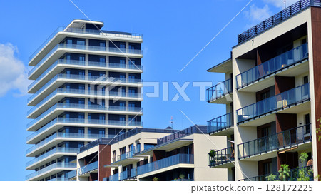 Exterior of a high modern multi-story apartment building - facade, windows and balconies. Modern glass balcony railings. 128172225