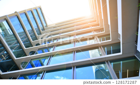 Downtown corporate business district architecture. Glass reflective office buildings against blue sky and sun light. Economy, finances, business activity concept. Abstract modern architecture fragment Downtown corporate business district architecture. Glass reflective office buildings against blue sky and sun light. Economy, finances, business activity concept. Abstract modern architecture fragment 128172287