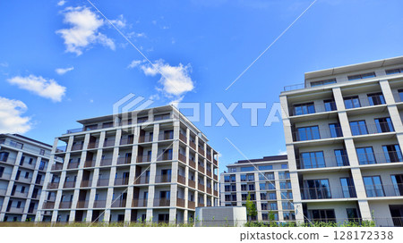 Modern apartment buildings on a sunny day with a blue sky. Facade of a modern apartment building. Modern residential apartment building complex condo. Modern apartment buildings on a sunny day with a blue sky. Facade of a modern apartment building. Modern residential apartment building complex condo. 128172338