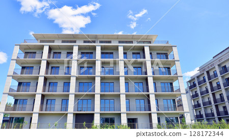Modern apartment buildings on a sunny day with a blue sky. Facade of a modern apartment building. Modern residential apartment building complex condo. Modern apartment buildings on a sunny day with a blue sky. Facade of a modern apartment building. Modern residential apartment building complex condo. 128172344