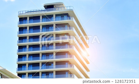Modern apartment buildings on a sunny day with a blue sky. Facade of a modern apartment building. Modern residential apartment building complex condo. Modern apartment buildings on a sunny day with a blue sky. Facade of a modern apartment building. Modern residential apartment building complex condo. 128172351