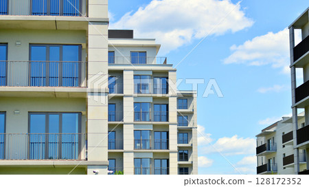 Modern apartment buildings on a sunny day with a blue sky. Facade of a modern apartment building. Modern residential apartment building complex condo. 128172352