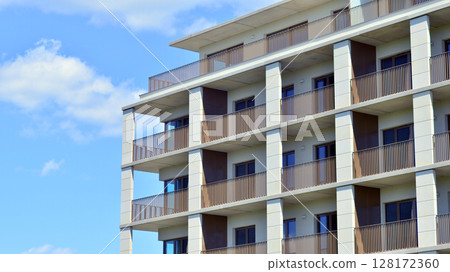 Modern apartment buildings on a sunny day with a blue sky. Facade of a modern apartment building. Modern residential apartment building complex condo. 128172360