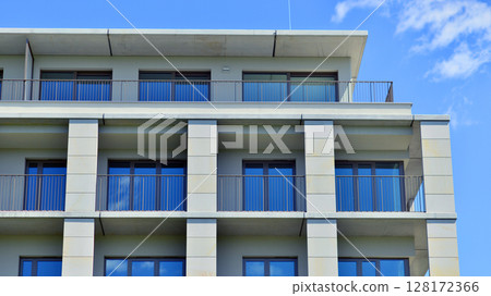 Modern apartment buildings on a sunny day with a blue sky. Facade of a modern apartment building. Modern residential apartment building complex condo. 128172366