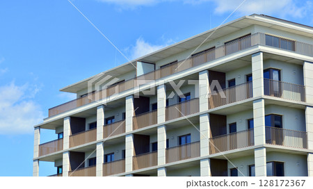 Modern apartment buildings on a sunny day with a blue sky. Facade of a modern apartment building. Modern residential apartment building complex condo. 128172367
