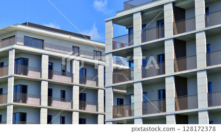 Modern apartment buildings on a sunny day with a blue sky. Facade of a modern apartment building. Modern residential apartment building complex condo. Modern apartment buildings on a sunny day with a blue sky. Facade of a modern apartment building. Modern residential apartment building complex condo. 128172378