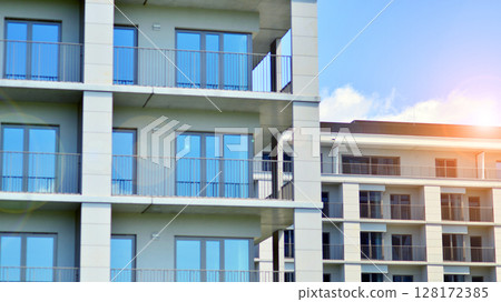Modern apartment buildings on a sunny day with a blue sky. Facade of a modern apartment building. Modern residential apartment building complex condo. Modern apartment buildings on a sunny day with a blue sky. Facade of a modern apartment building. Modern residential apartment building complex condo. 128172385
