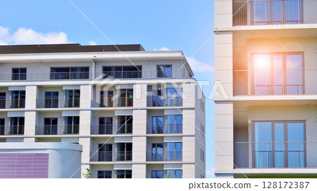 Modern apartment buildings on a sunny day with a blue sky. Facade of a modern apartment building. Modern residential apartment building complex condo. Modern apartment buildings on a sunny day with a blue sky. Facade of a modern apartment building. Modern residential apartment building complex condo. 128172387