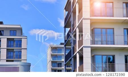 Modern apartment buildings on a sunny day with a blue sky. Facade of a modern apartment building. Modern residential apartment building complex condo. 128172390