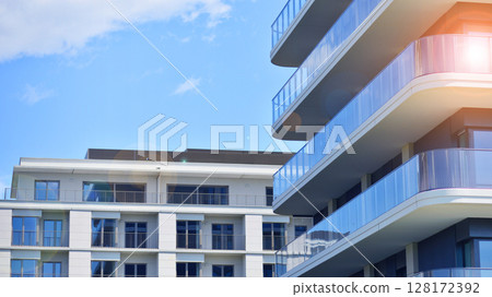 Modern apartment buildings on a sunny day with a blue sky. Facade of a modern apartment building. Modern residential apartment building complex condo. 128172392