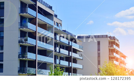 Modern apartment buildings on a sunny day with a blue sky. Facade of a modern apartment building. Modern residential apartment building complex condo. 128172395