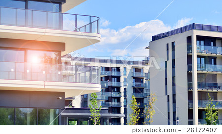Modern apartment buildings on a sunny day with a blue sky. Facade of a modern apartment building. Modern residential apartment building complex condo. Modern apartment buildings on a sunny day with a blue sky. Facade of a modern apartment building. Modern residential apartment building complex condo. 128172407