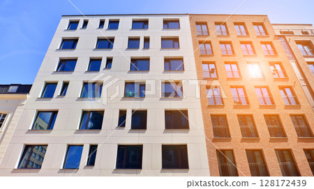 Modern apartment buildings on a sunny day with a blue sky. Facade of a modern apartment building. Modern residential apartment building complex condo. Modern apartment buildings on a sunny day with a blue sky. Facade of a modern apartment building. Modern residential apartment building complex condo. 128172439