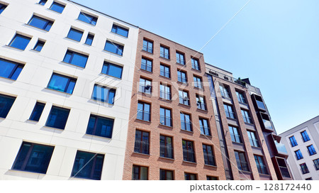 Modern apartment buildings on a sunny day with a blue sky. Facade of a modern apartment building. Modern residential apartment building complex condo. Modern apartment buildings on a sunny day with a blue sky. Facade of a modern apartment building. Modern residential apartment building complex condo. 128172440