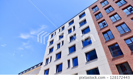 Modern apartment buildings on a sunny day with a blue sky. Facade of a modern apartment building. Modern residential apartment building complex condo. Modern apartment buildings on a sunny day with a blue sky. Facade of a modern apartment building. Modern residential apartment building complex condo. 128172443