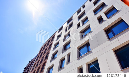 Modern apartment buildings on a sunny day with a blue sky. Facade of a modern apartment building. Modern residential apartment building complex condo. 128172446