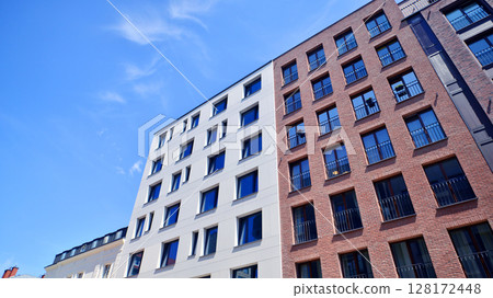 Modern apartment buildings on a sunny day with a blue sky. Facade of a modern apartment building. Modern residential apartment building complex condo. 128172448