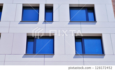 Modern apartment buildings on a sunny day with a blue sky. Facade of a modern apartment building. Modern residential apartment building complex condo. 128172452