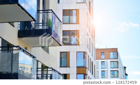 Modern apartment buildings on a sunny day with a blue sky. Facade of a modern apartment building. Modern residential apartment building complex condo. 128172459