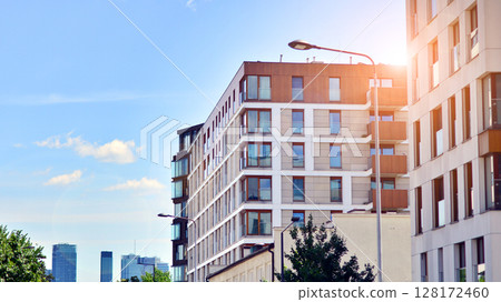 Modern apartment buildings on a sunny day with a blue sky. Facade of a modern apartment building. Modern residential apartment building complex condo. 128172460