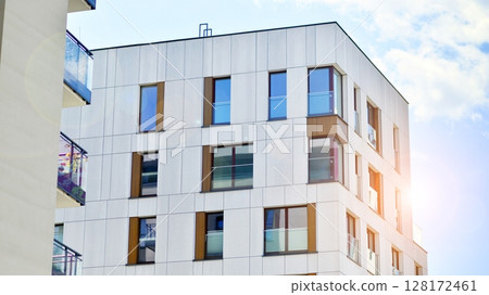Modern apartment buildings on a sunny day with a blue sky. Facade of a modern apartment building. Modern residential apartment building complex condo. 128172461