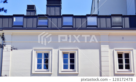 Modern apartment buildings on a sunny day with a blue sky. Facade of a modern apartment building. Modern residential apartment building complex condo. 128172478