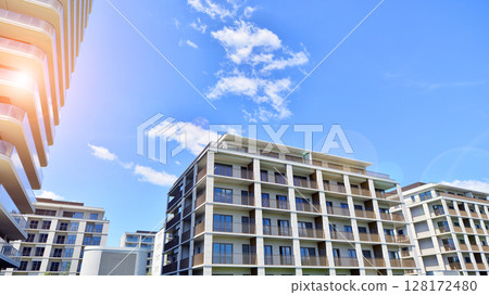 Modern apartment buildings on a sunny day with a blue sky. Facade of a modern apartment building. Modern residential apartment building complex condo. 128172480