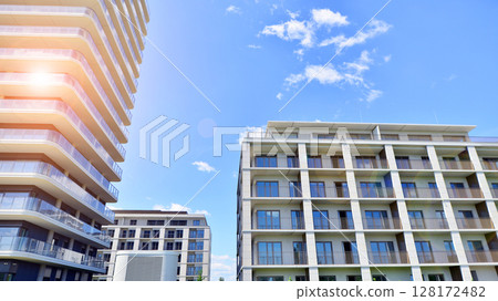 Modern apartment buildings on a sunny day with a blue sky. Facade of a modern apartment building. Modern residential apartment building complex condo. Modern apartment buildings on a sunny day with a blue sky. Facade of a modern apartment building. Modern residential apartment building complex condo. 128172482