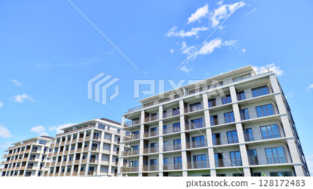 Modern apartment buildings on a sunny day with a blue sky. Facade of a modern apartment building. Modern residential apartment building complex condo. Modern apartment buildings on a sunny day with a blue sky. Facade of a modern apartment building. Modern residential apartment building complex condo. 128172483