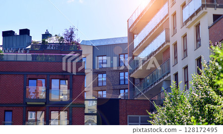 European residential architecture harmonizing with nature. Eco-friendly living in city with greens. Eco apartment building saving energy and fresh air concept.  128172495