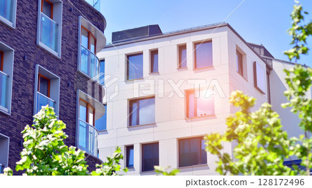 European residential architecture harmonizing with nature. Eco-friendly living in city with greens. Eco apartment building saving energy and fresh air concept. European residential architecture harmonizing with nature. Eco-friendly living in city with greens. Eco apartment building saving energy and fresh air concept. 128172496