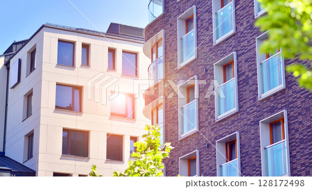 European residential architecture harmonizing with nature. Eco-friendly living in city with greens. Eco apartment building saving energy and fresh air concept.  128172498