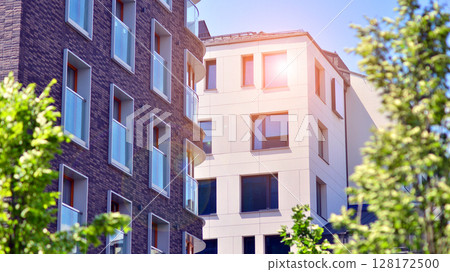 European residential architecture harmonizing with nature. Eco-friendly living in city with greens. Eco apartment building saving energy and fresh air concept. European residential architecture harmonizing with nature. Eco-friendly living in city with greens. Eco apartment building saving energy and fresh air concept. 128172500