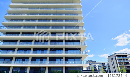 Exterior of a high modern multi-story apartment building - facade, windows and balconies. 128172544