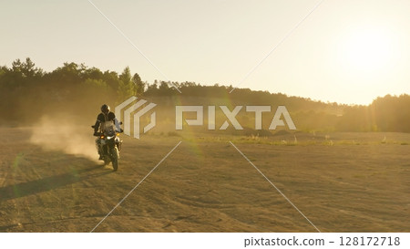 Man, professional motorcyclist in full moto equipment riding crops enduro bike on mountain road at sunset. Concept of motosport, speed, hobby, journey, activity Man, professional motorcyclist in full moto equipment riding crops enduro bike on mountain road at sunset. Concept of motosport, speed, hobby, journey, activity 128172718