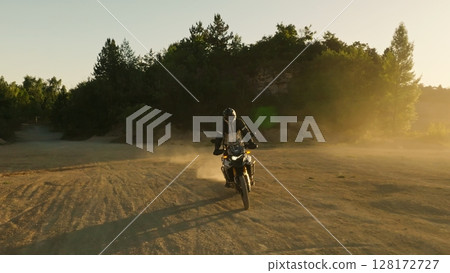 Man, professional motorcyclist in full moto equipment riding crops enduro bike on mountain road at sunset. Concept of motosport, speed, hobby, journey, activity Man, professional motorcyclist in full moto equipment riding crops enduro bike on mountain road at sunset. Concept of motosport, speed, hobby, journey, activity 128172727