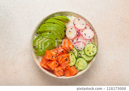 Salmon poke bowl with avocado, radish, cucumber and rice on light beige background top view 128173008