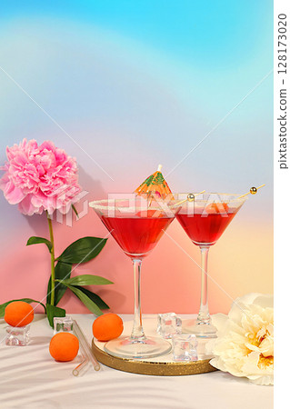 Minimal summer party concept, advertising banner for bar, cafe. Modern still life with pink martini, summer alcoholic cocktail with apricot for party and peonies on elegant modern background 128173020