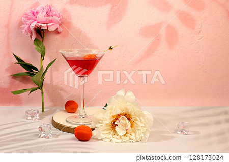 Minimal summer party concept, advertising banner for bar, cafe. Modern still life with pink martini, summer alcoholic cocktail with apricot for party and peonies on elegant modern background 128173024