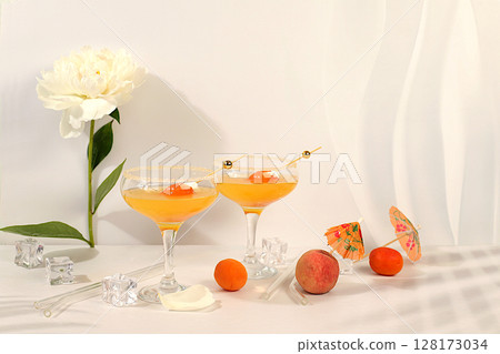 Iced punch with apricots for party,Modern still life with summer alcoholic cocktail and peonies on modern sunny background, minimalist concept for bar cafe, advertising banner 128173034