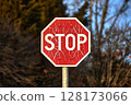 Stop sign with broken paint peeling 128173066