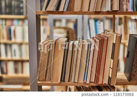 Books and shelves of a library 128173068