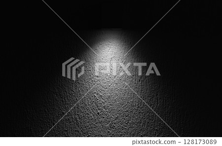 A focused spotlight highlighting the texture of a rough wall surface 128173089