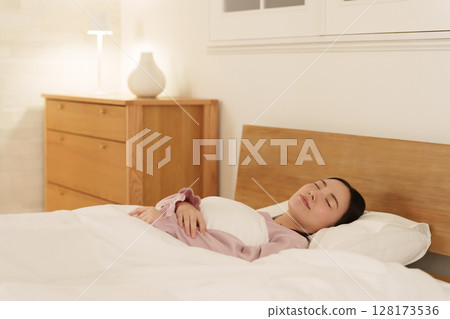 晚上在床上睡覺的女人 128173536