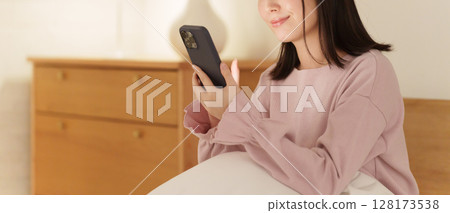 A woman looking at her smartphone in the middle of the night 128173538