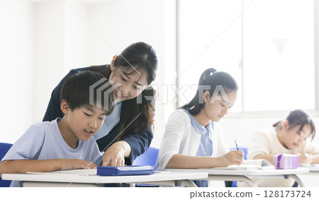 正在學習的小學生和他們的老師 正在學習的小學生和他們的老師 128173724