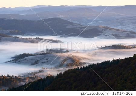 Amazing flowing morning fog spreads over freeze meadows 128174202